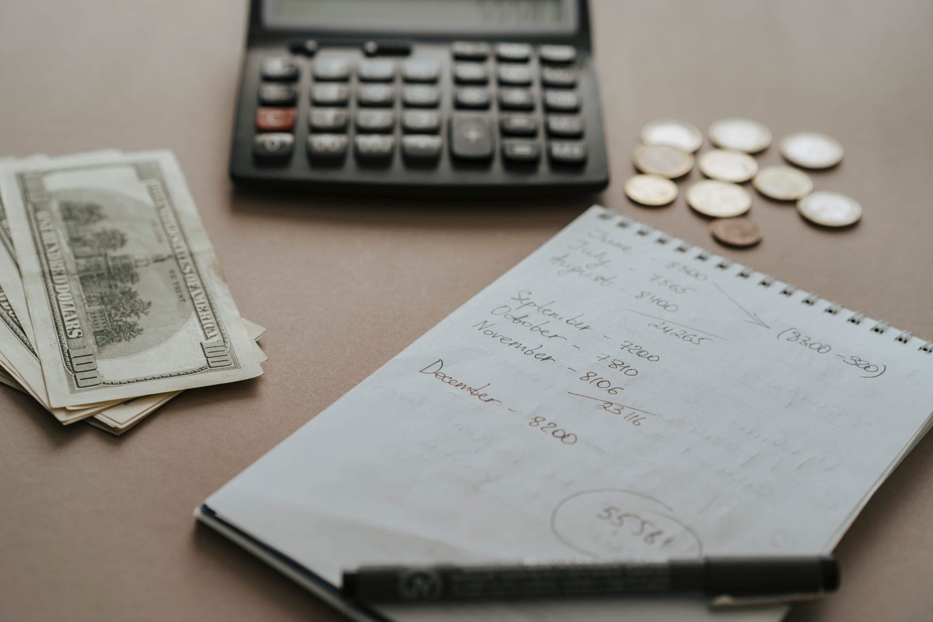 Coins and a notebook, illustrating a budget calculation