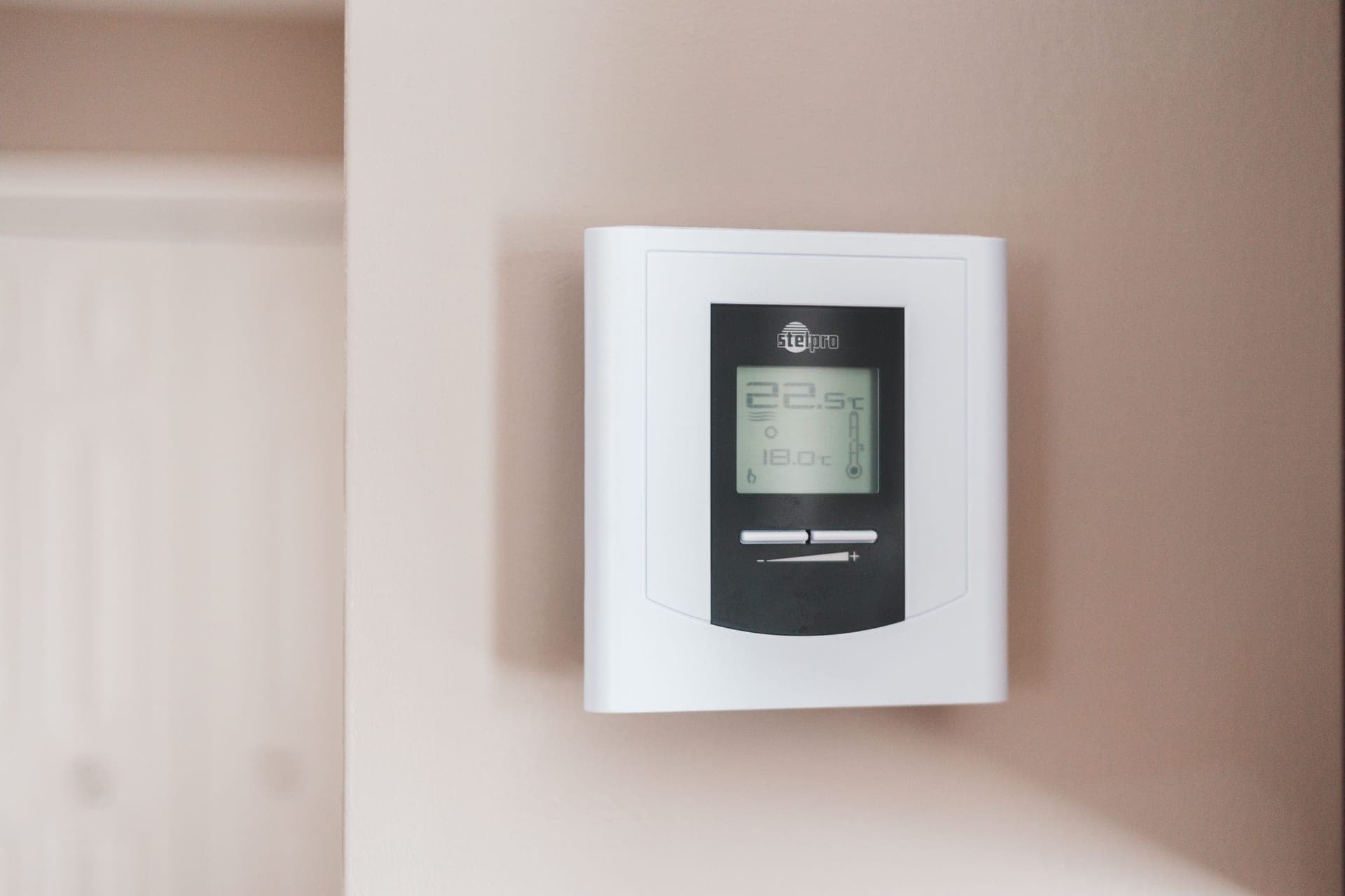 A digital thermostat unit on a wall